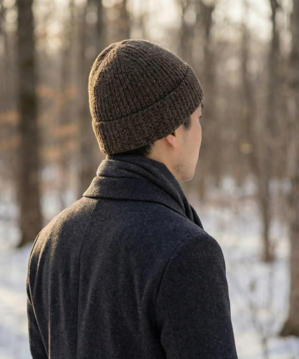 Rear view of man outdoors wearing a unisex ribbed yak wool hat in mottled dark brown