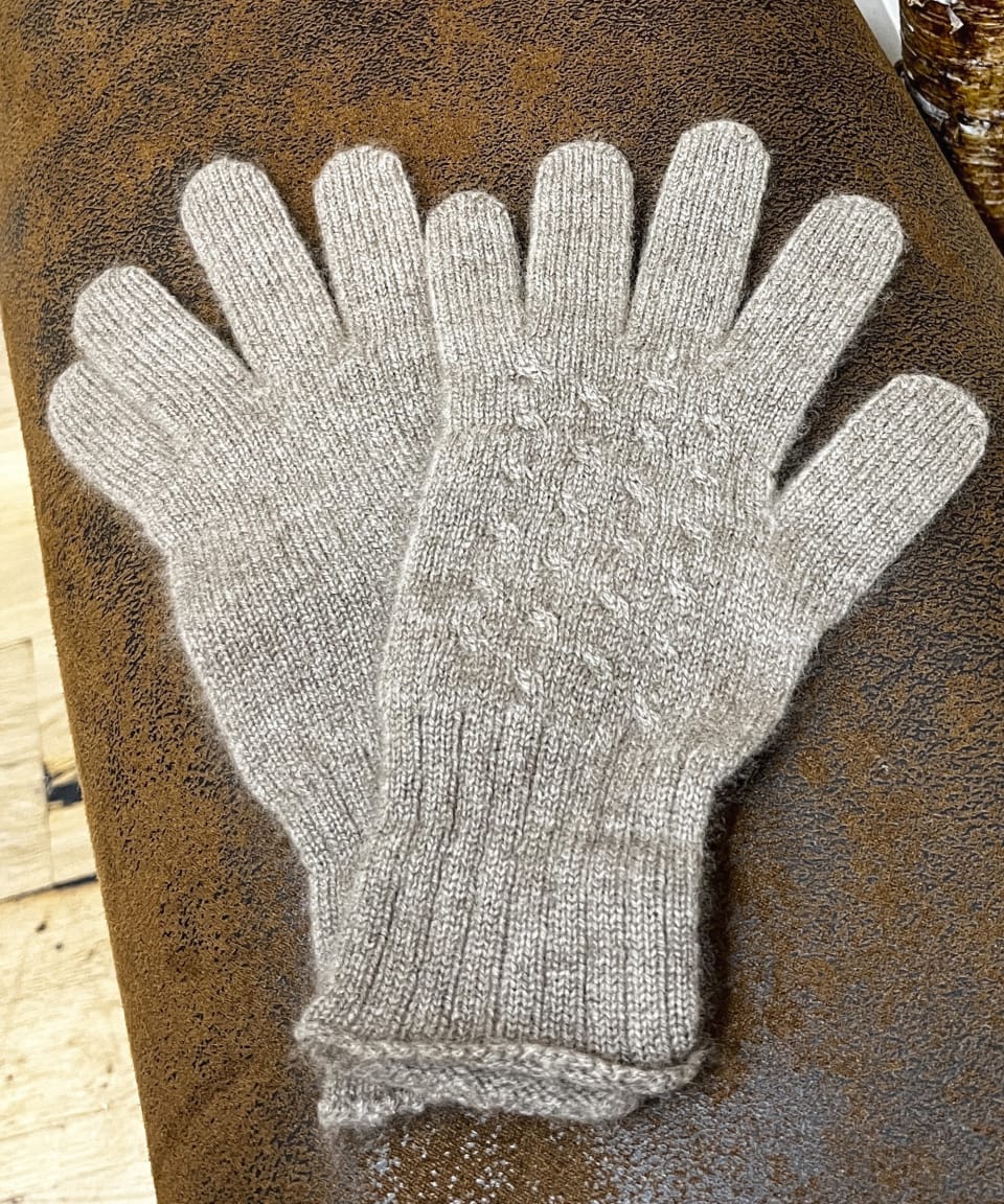 Natural brown cashmere gloves on neutral background, flat view