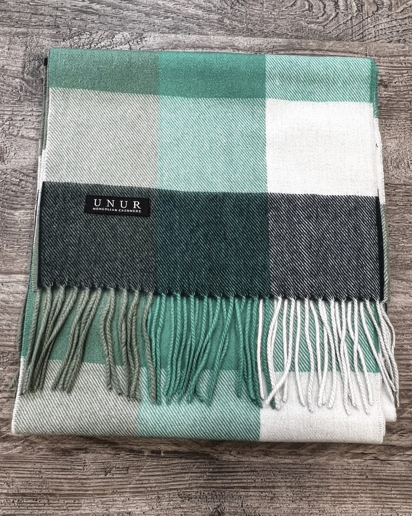Lay-flat close up of check sage, green and cream unisex woven cashmere scarf with tassels