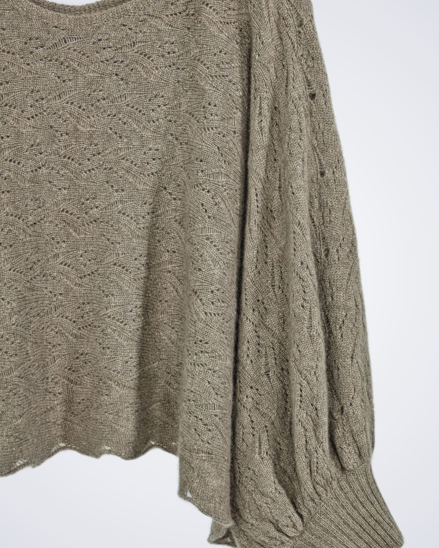 Close up of a patterned poncho-style cashmere jumper