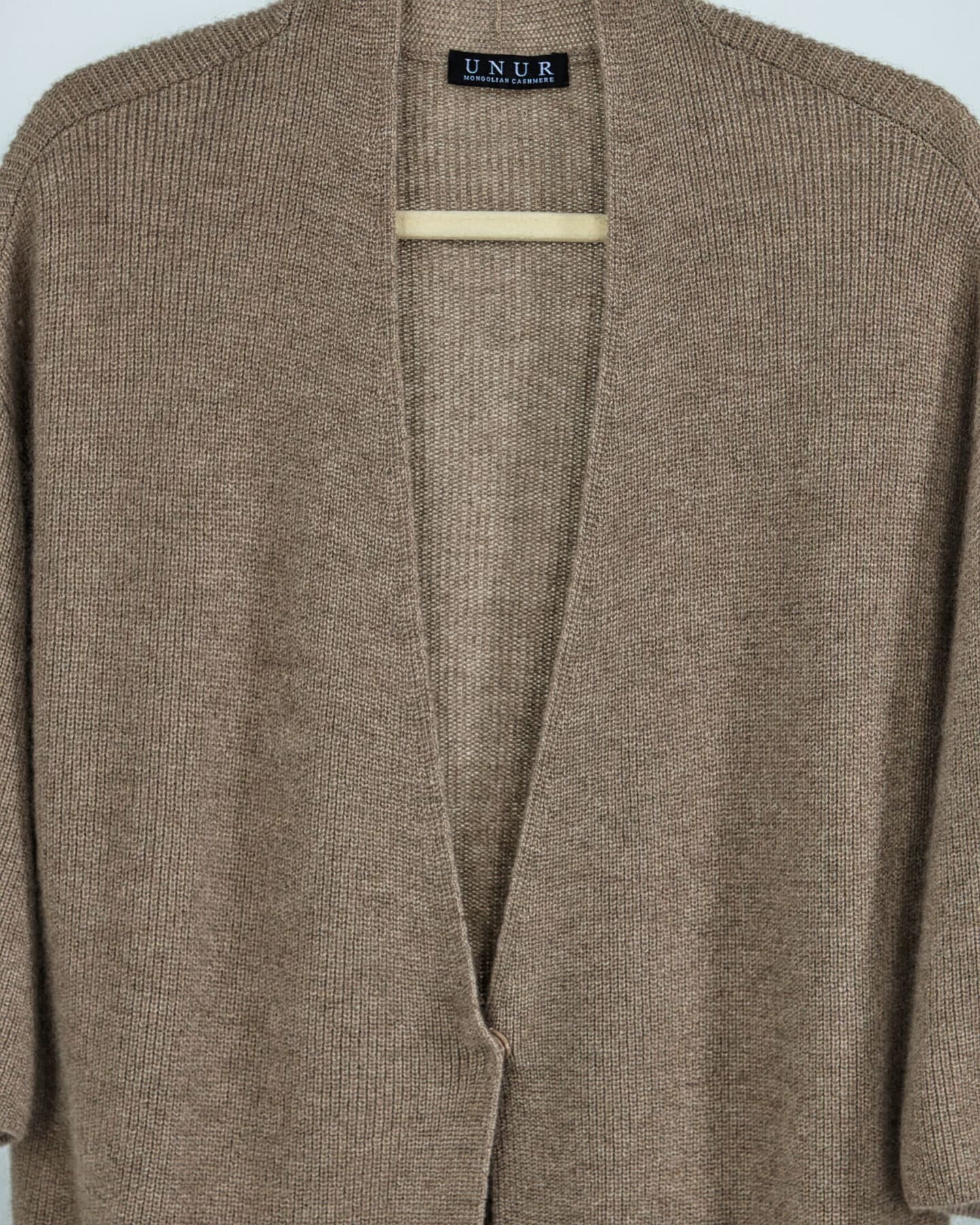 Close-up of soft cashmere ribbed cardigan in natural brown
