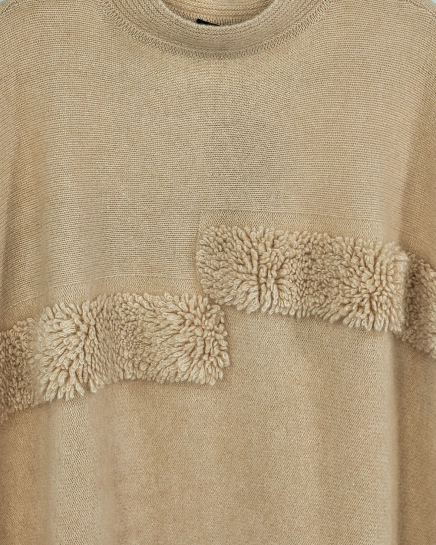 Close-up of soft cashmere ribbed poncho in natural beige