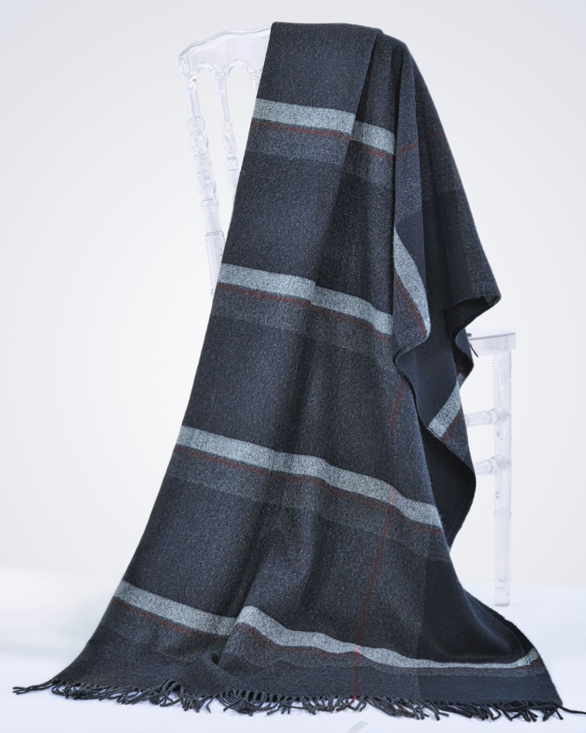 charcoal cashmere blanket with plaid stripes draped over a chair