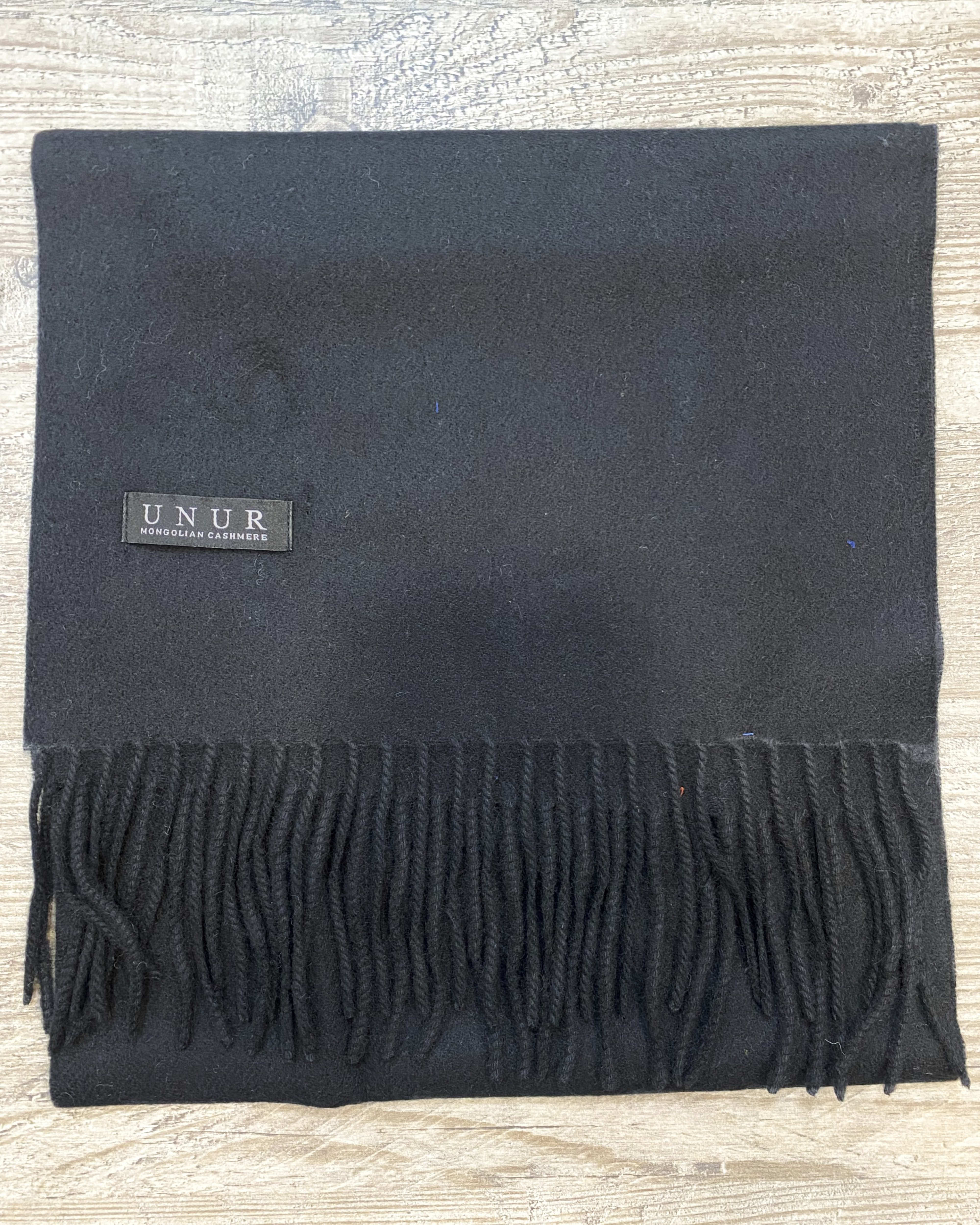 Lay-flat close up of black unisex woven cashmere scarf with tassles