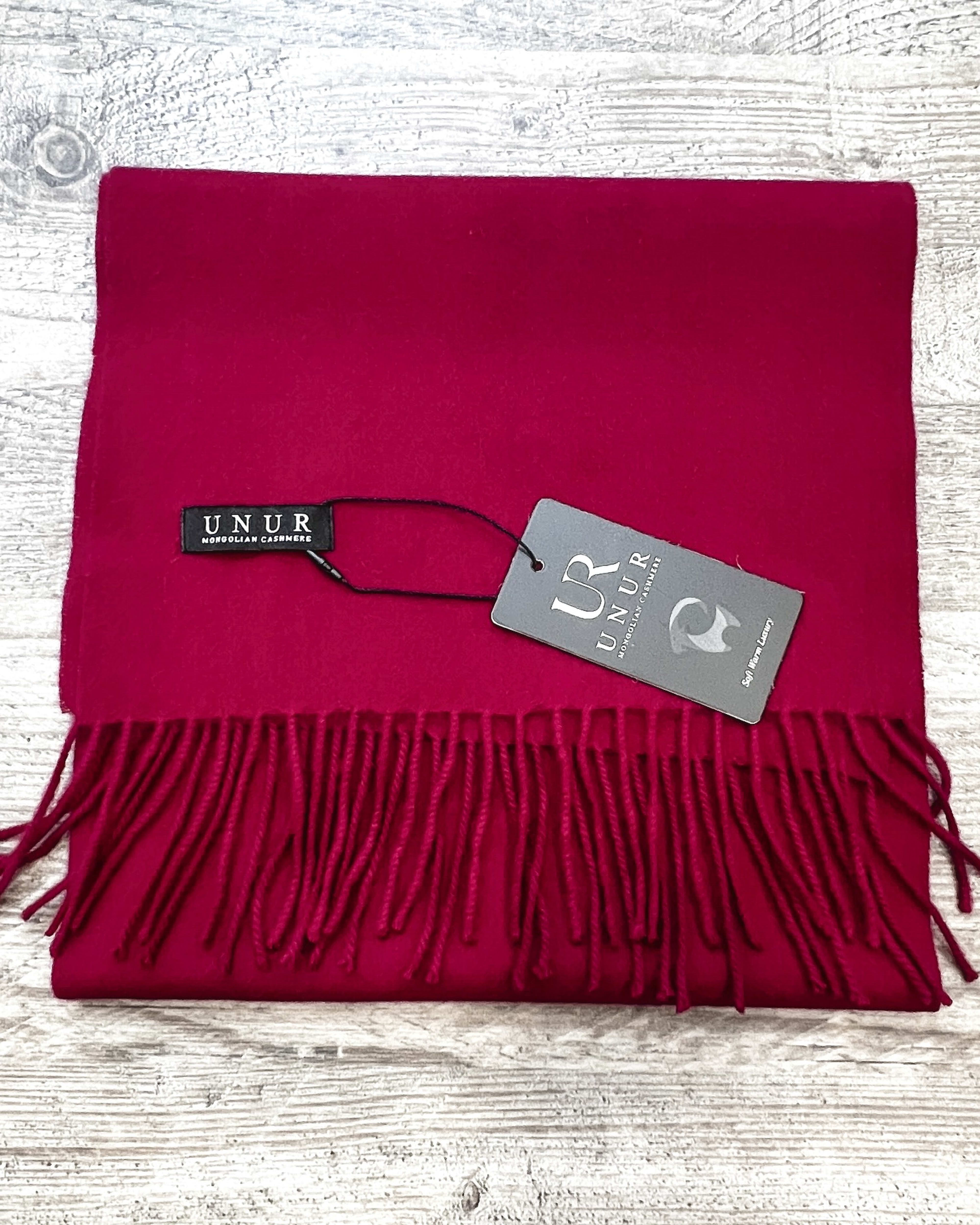 Lay-flat close up of burgundy unisex woven cashmere scarf with tassles