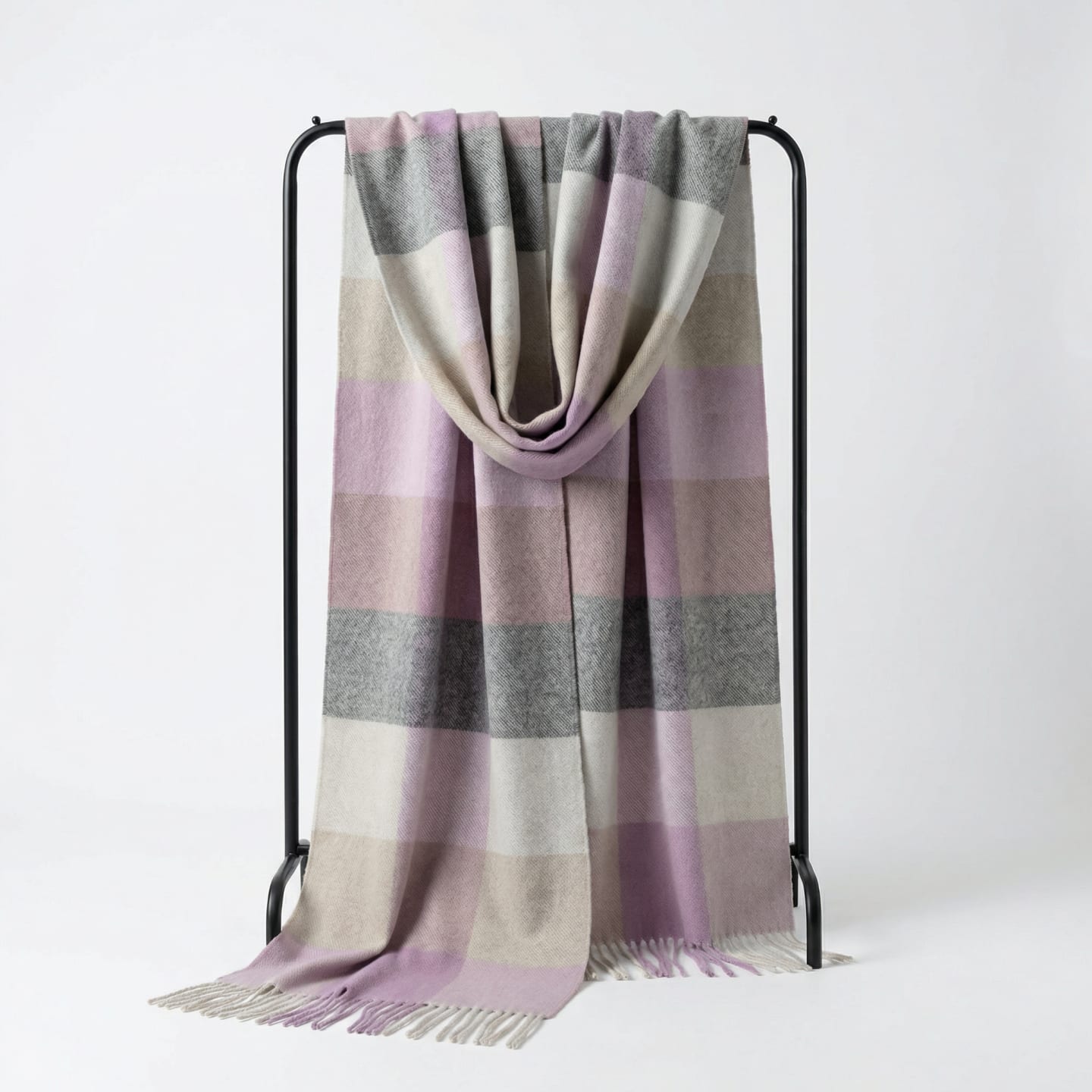 Unisex woven cashmere scarf in check pink, draped over a hanger