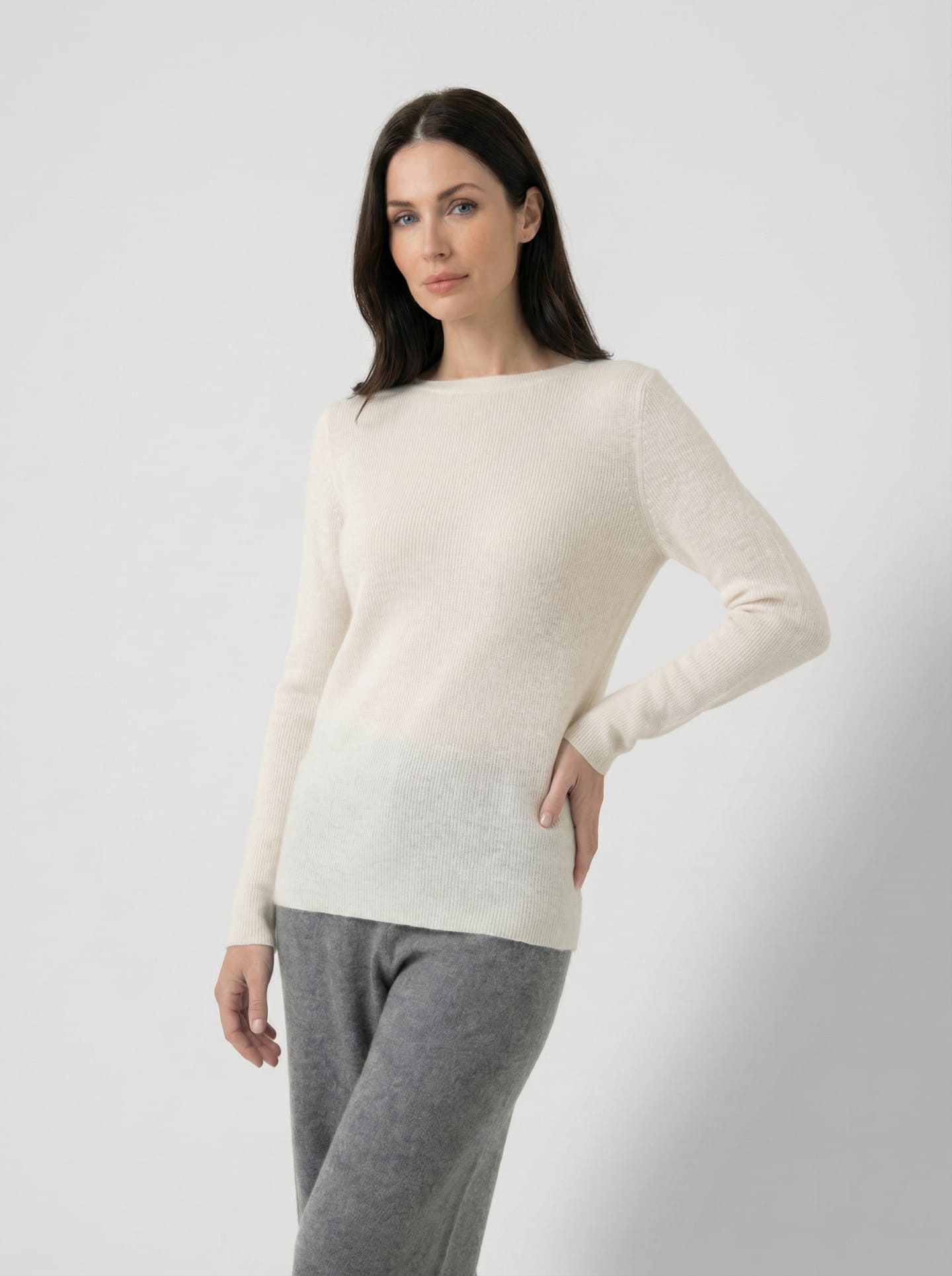Woman wearing off-white cashmere jumper with fine vertical rib, boat neckline and long sleeves – Unur