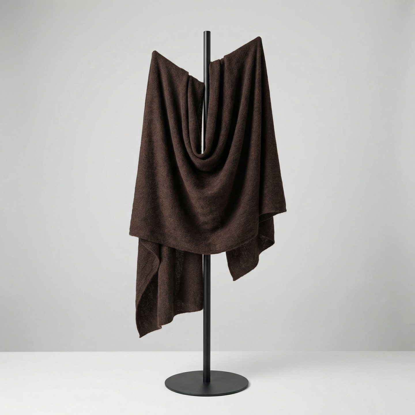 Textured yak wool shawl in dark brown draped over a hanger