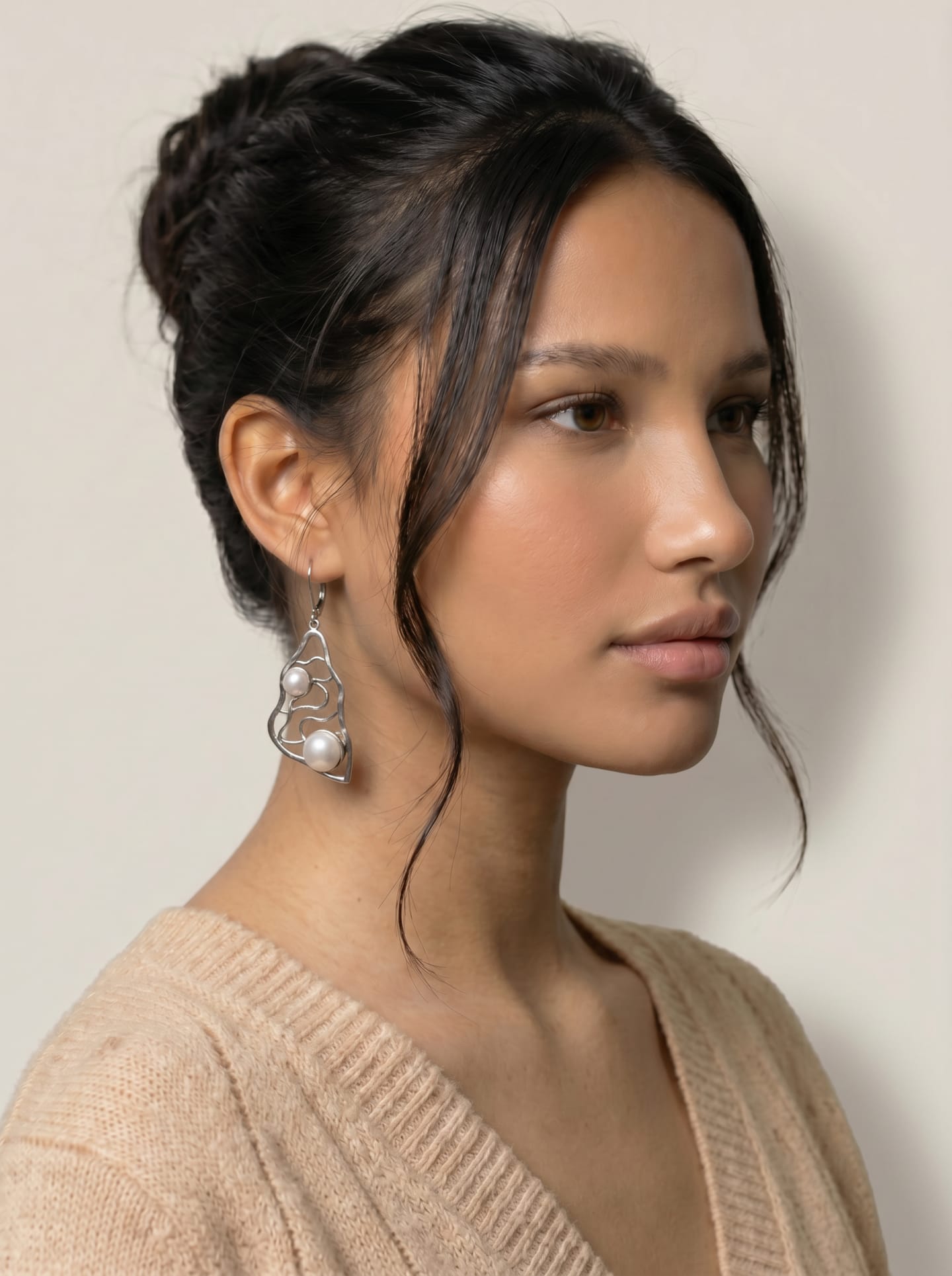 Model wearing one Signature Silver Lattice Drop Earring, profile view over a soft beige cashmere sweater.