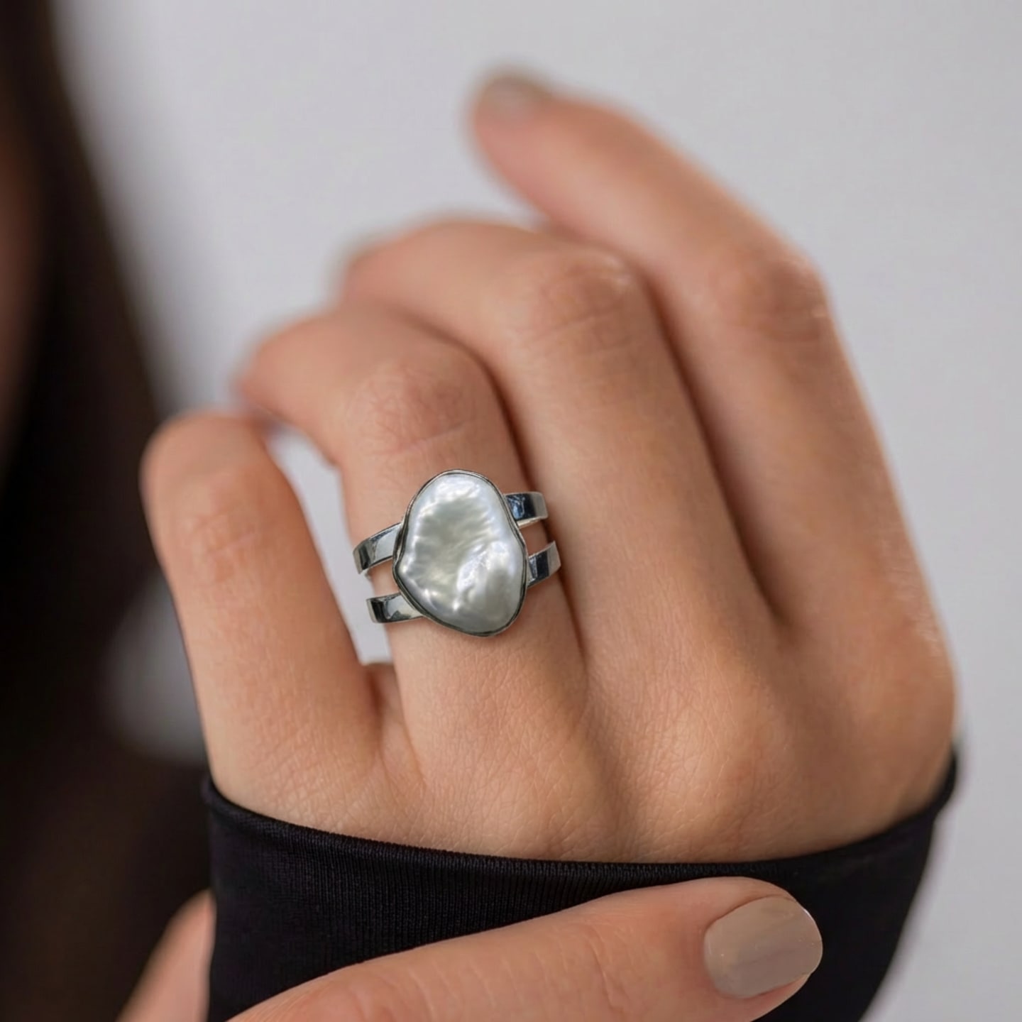 Hand wearing the Signature Keshi Pearl Double Band Statement Ring, freeform freshwater pearl bezel-set on rhodium-plated silver