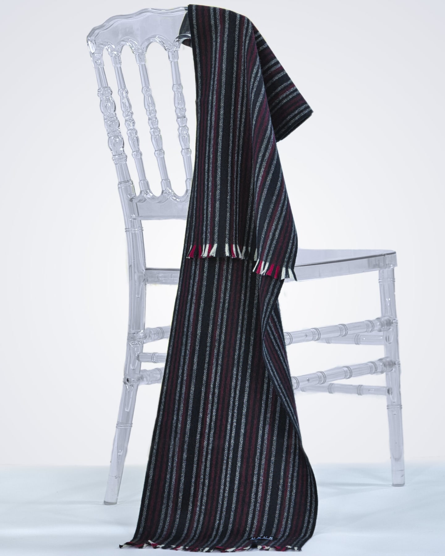 Men's cashmere pinstriped scarf on neutral background, draped on a chair