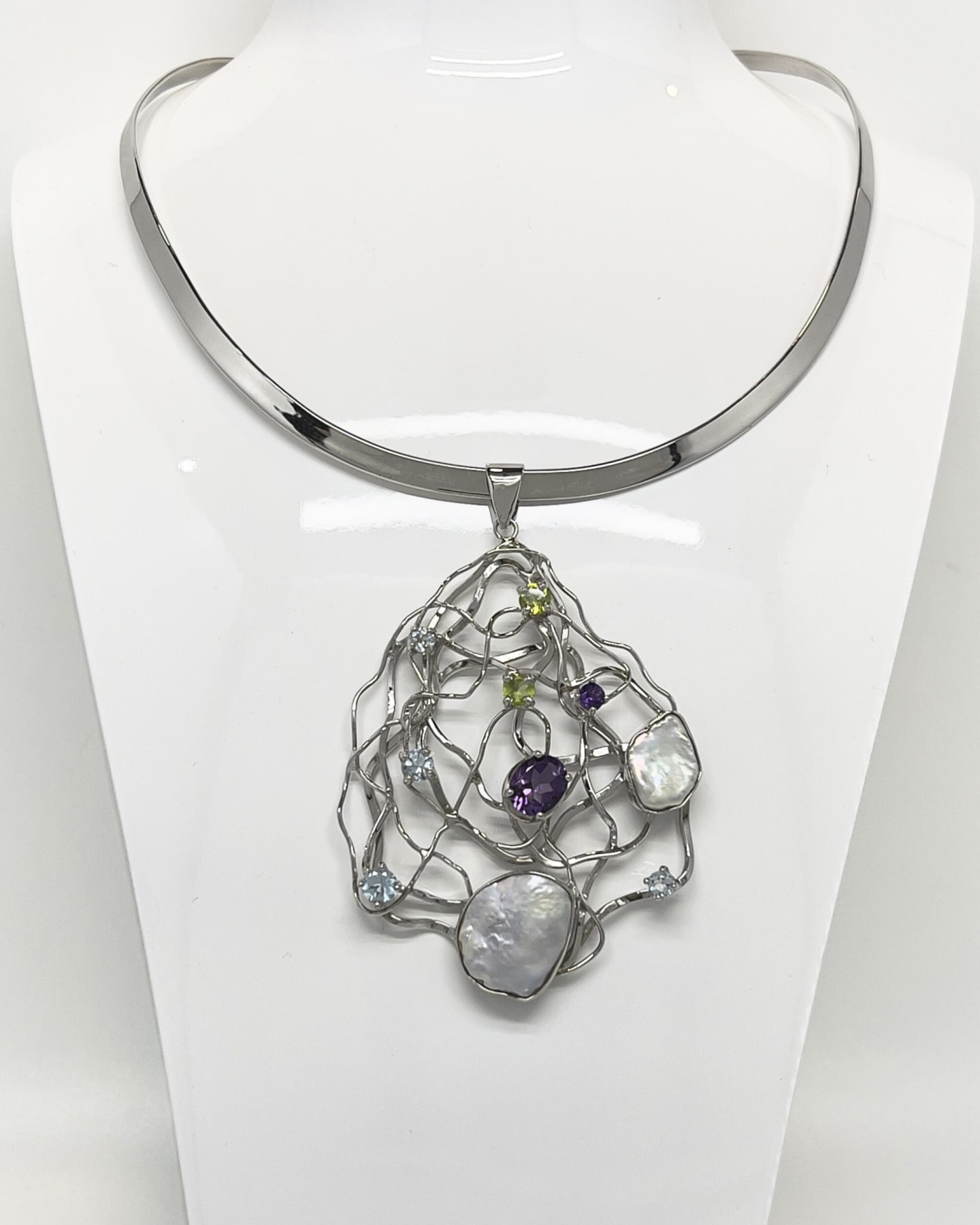 Silver torque collar suspending an openwork lattice pendant set with keshi pearls, amethyst, peridot and topaz.