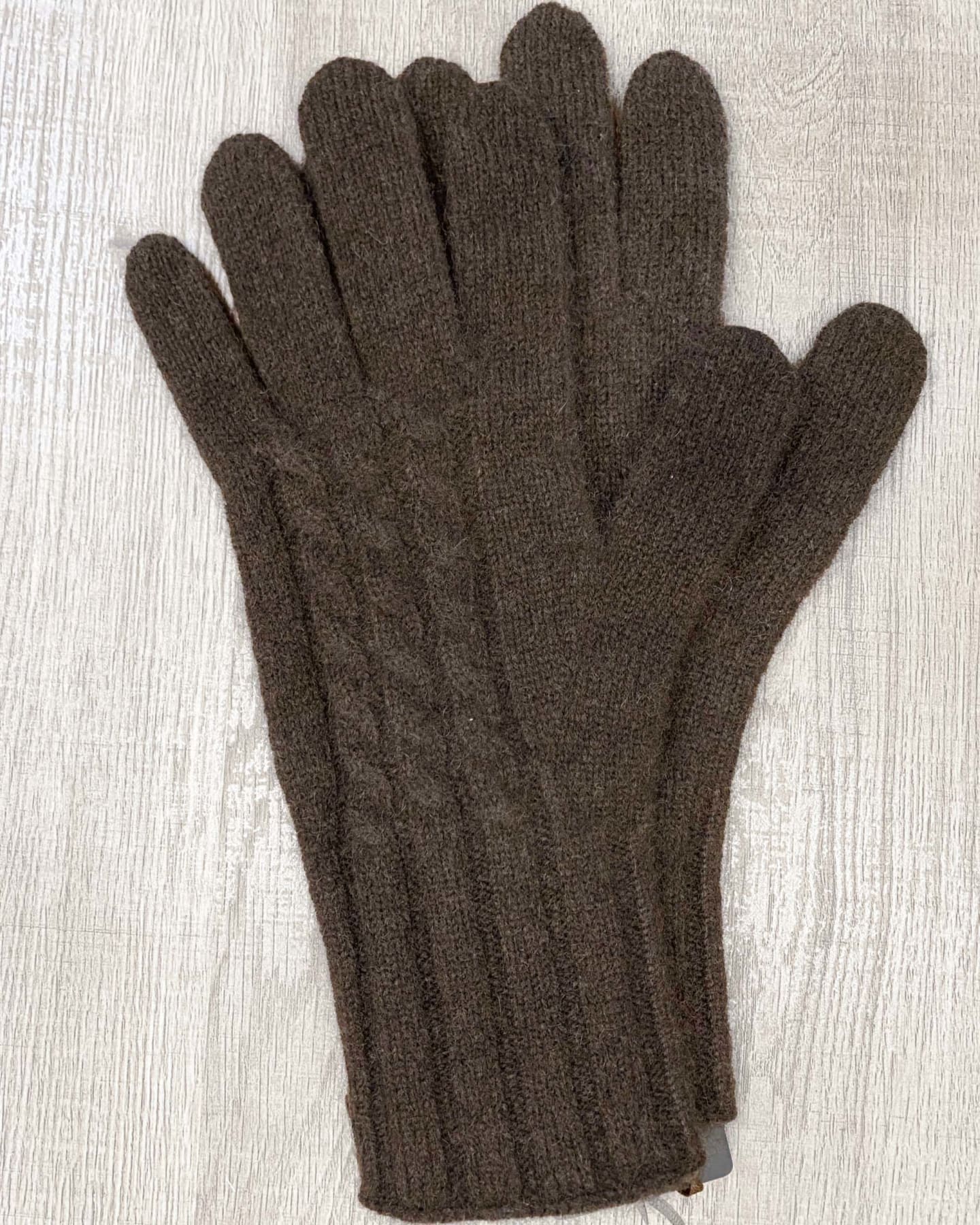 Dark brown yak wool gloves on neutral background, flat view