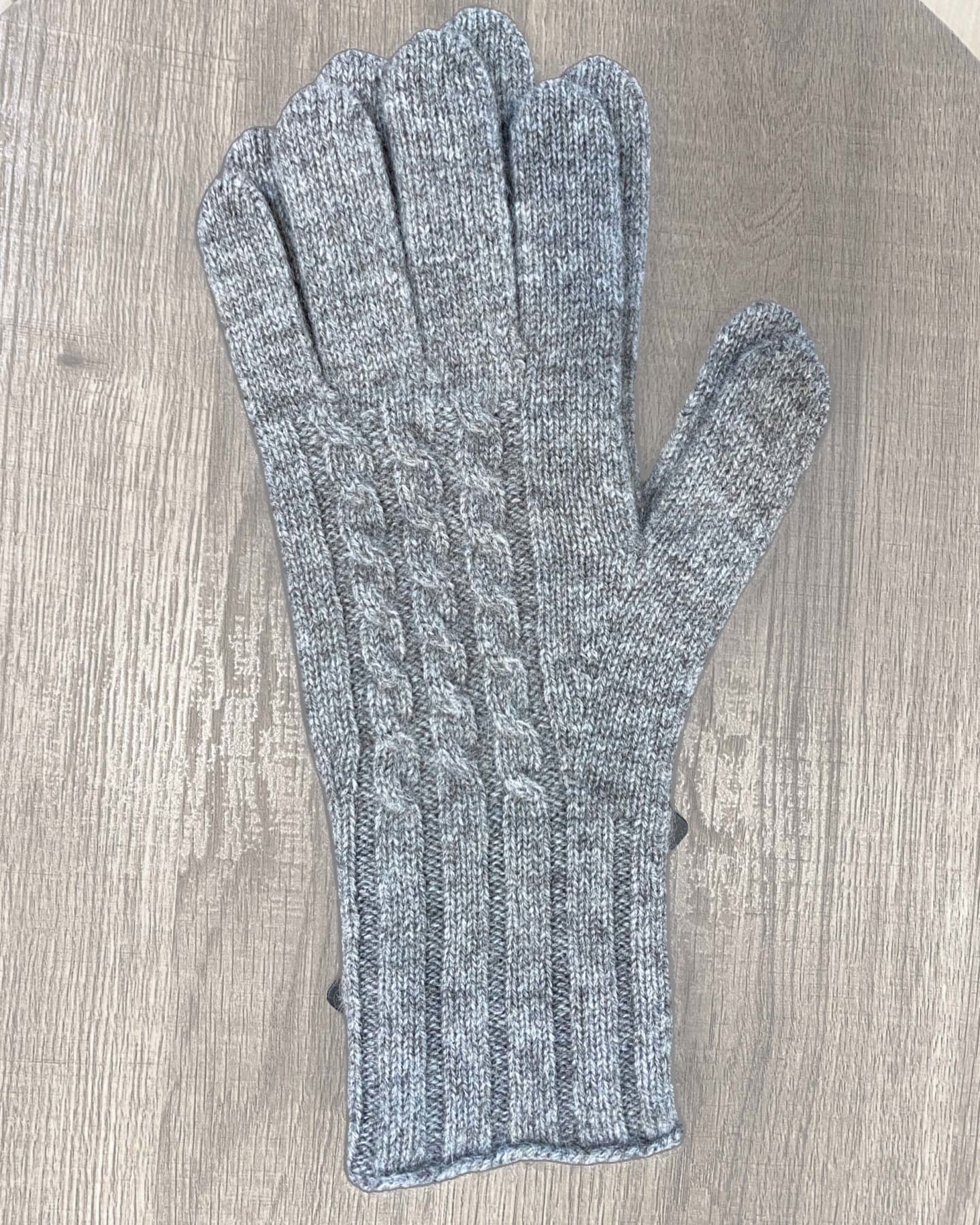 Natural brown yak wool gloves on neutral background, flat view