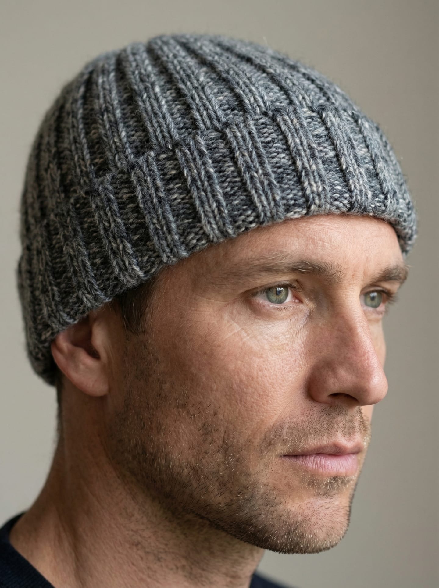Front view of a man wearing chunky ribbed yak wool hat in mottled grey