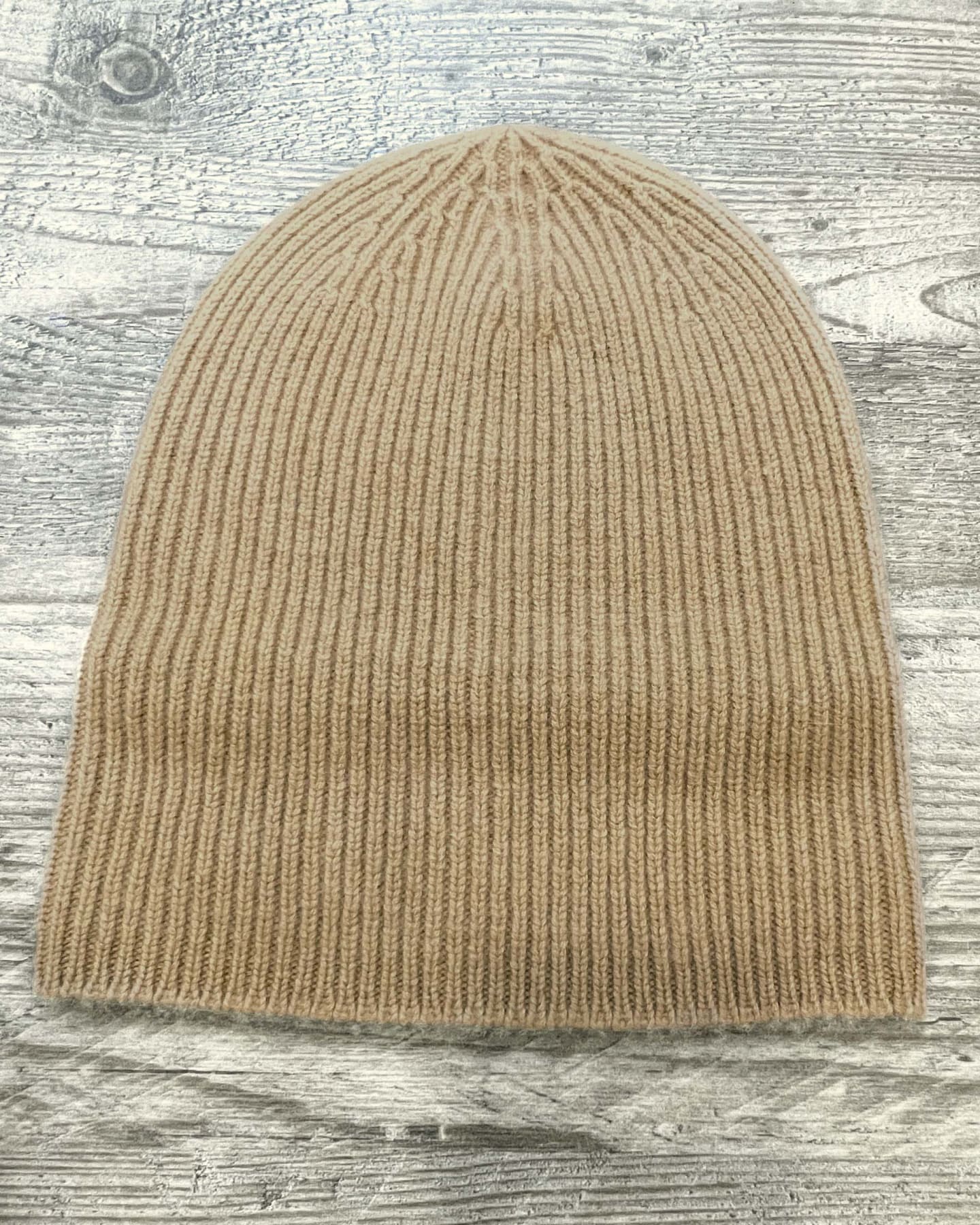 Camel beige ribbed cashmere hat on neutral background, flat view