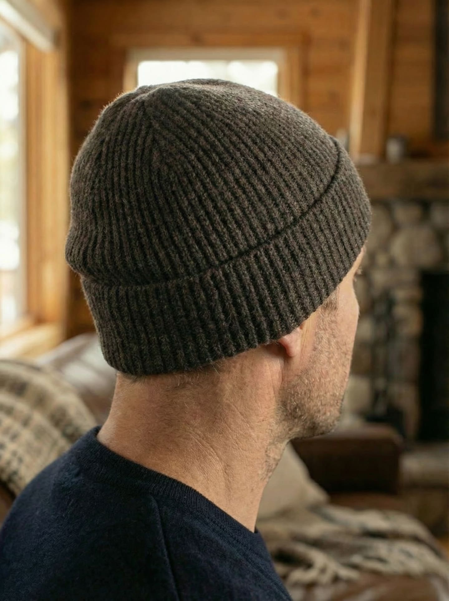 Back view of man indoors wearing ribbed yak wool hat in dark brown