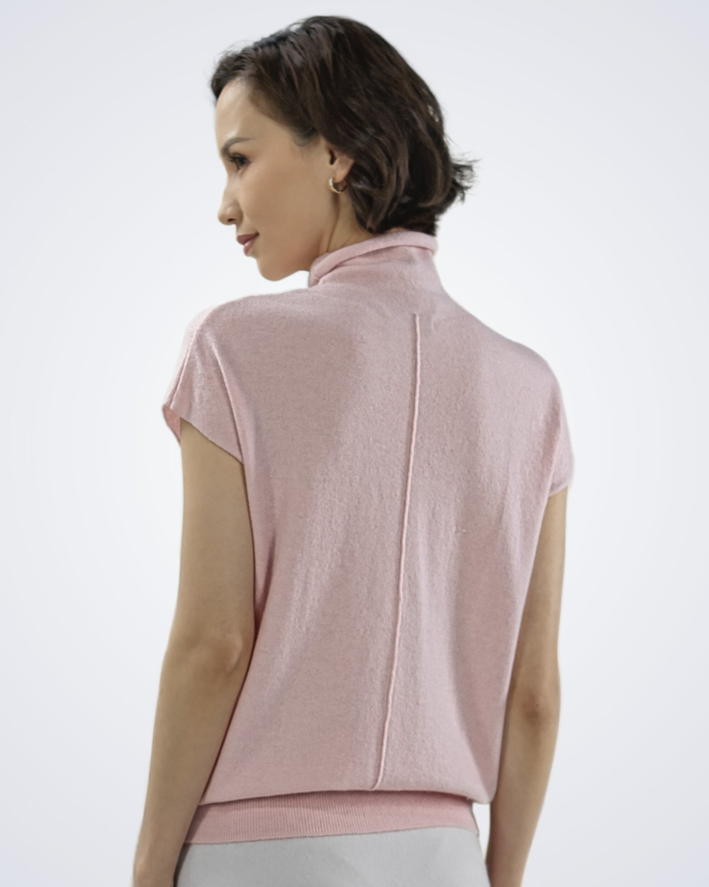 Back view of the women's high neck cashmere vest in pink, showing the centre-back seam and ribbed hem – Unur
