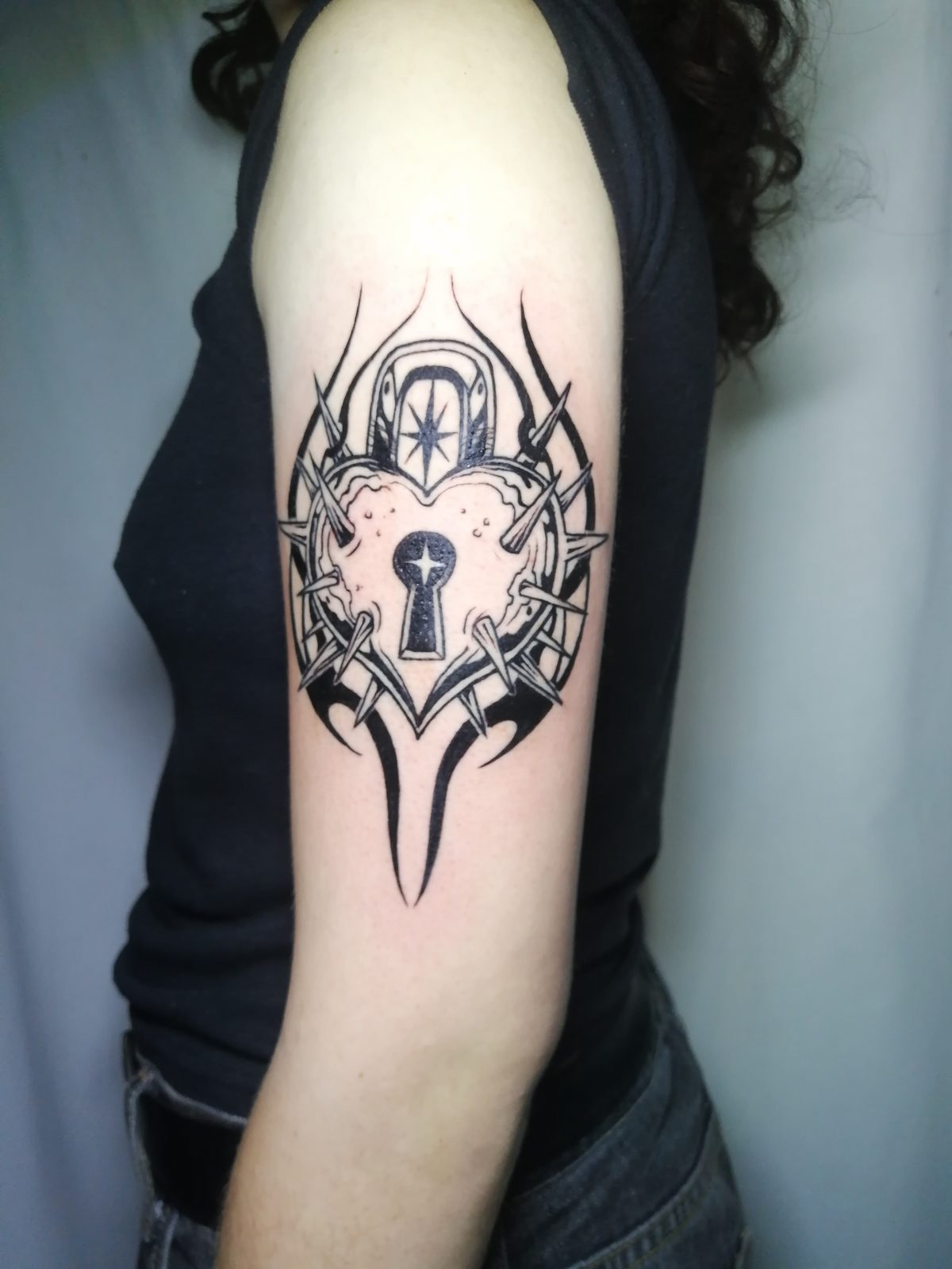 Candado y espinas en el brazo, por Brian