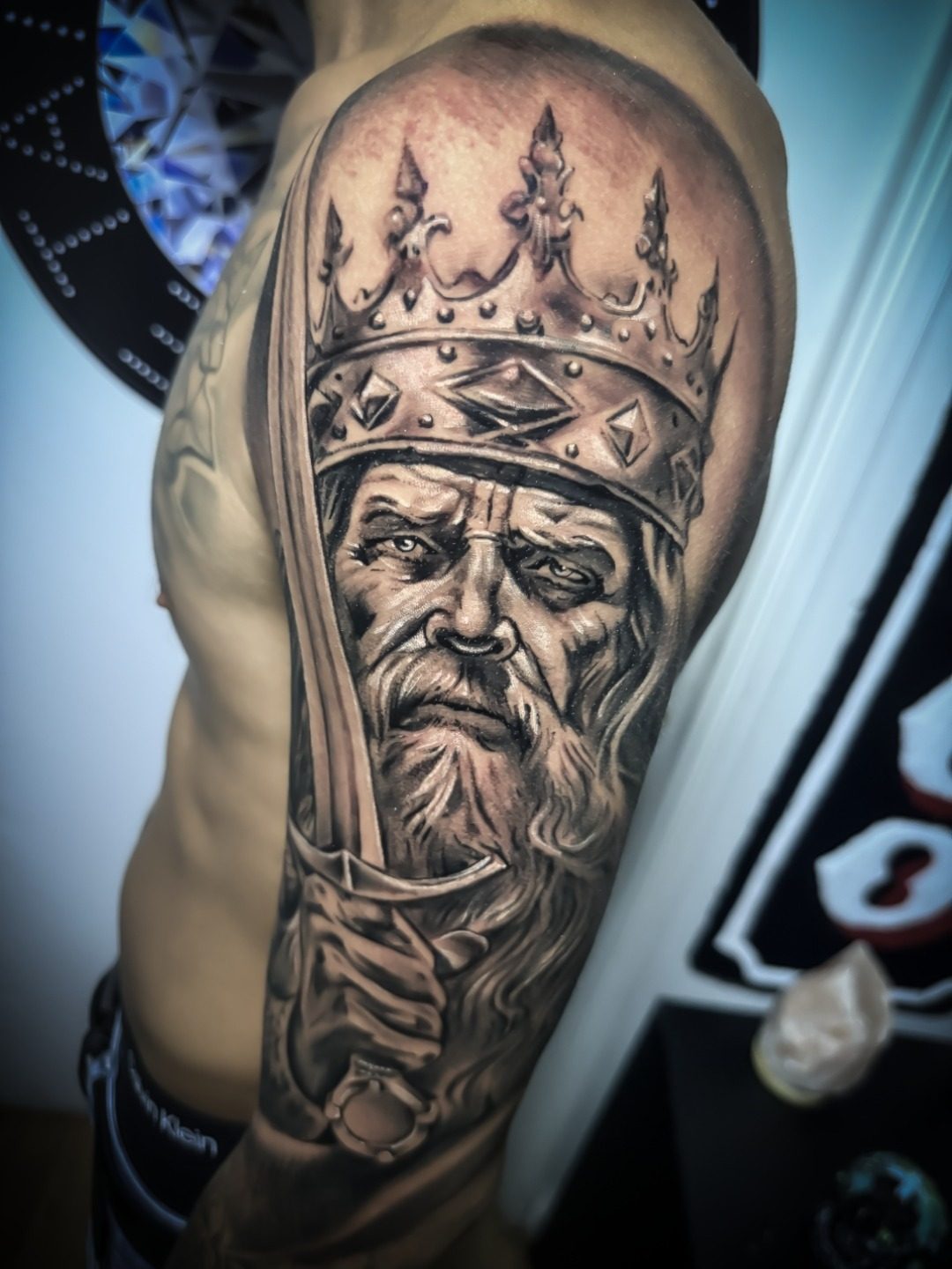 Rey coronado en el brazo, estilo realismo, por Brian
