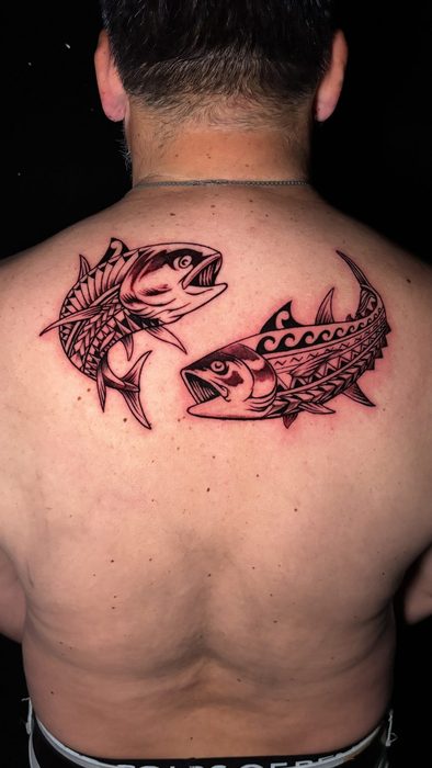 Espalda con dos peces en blackwork, estilo polinésico, por Gabriel Púas