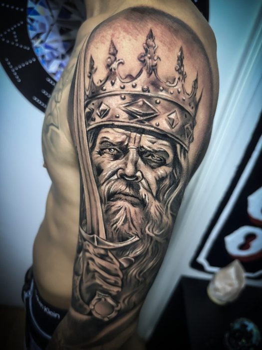 Rey coronado en el brazo, estilo realismo, por Brian
