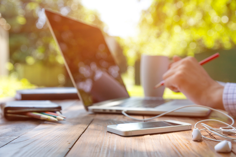 Working on laptop outside on table, remote work