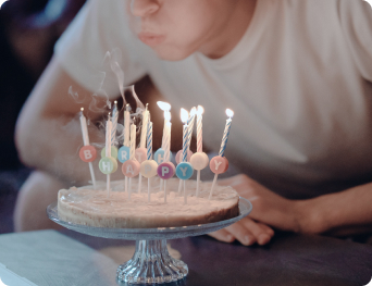 boy in white crew neck t shirt blowing candles on cake