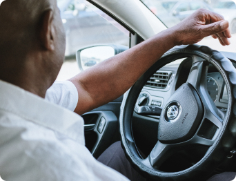 man in white shirt driving car