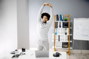 Man standing and stretching in the office