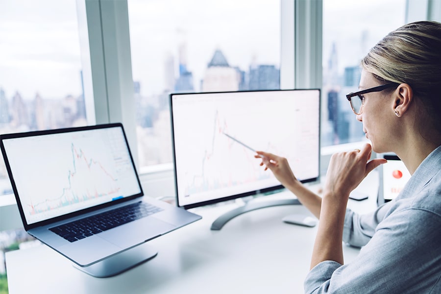 Woman working on laptop that has been raised to eye level