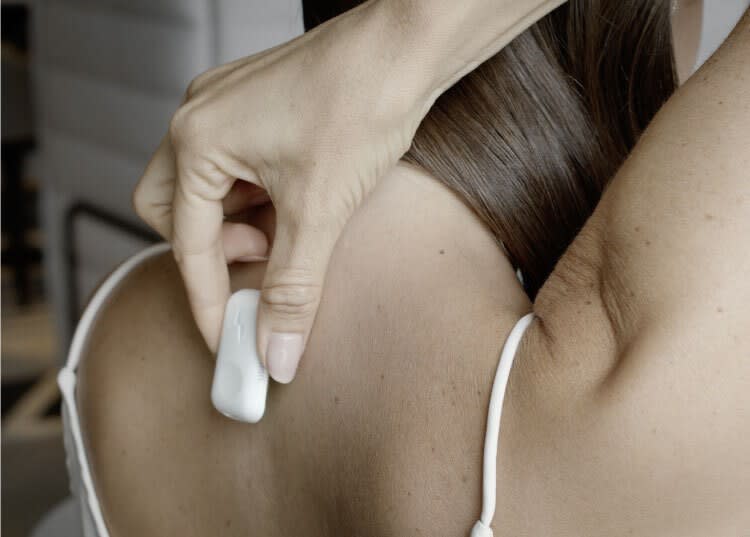 Woman placing Upright device on her upper back