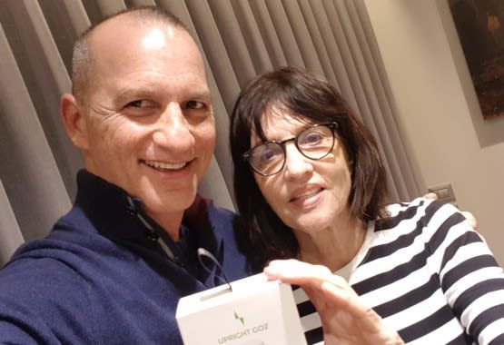 CEO of Upright and his mother posing with Upright Go2, which helped them stop slouching