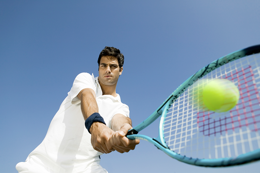 Tennis player hitting the ball with his racket