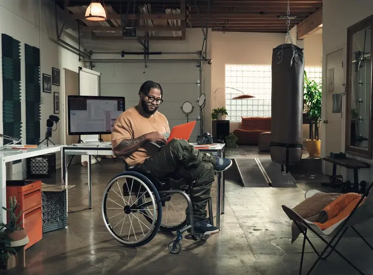 Woman sitting at a desk in an office and working on a laptop