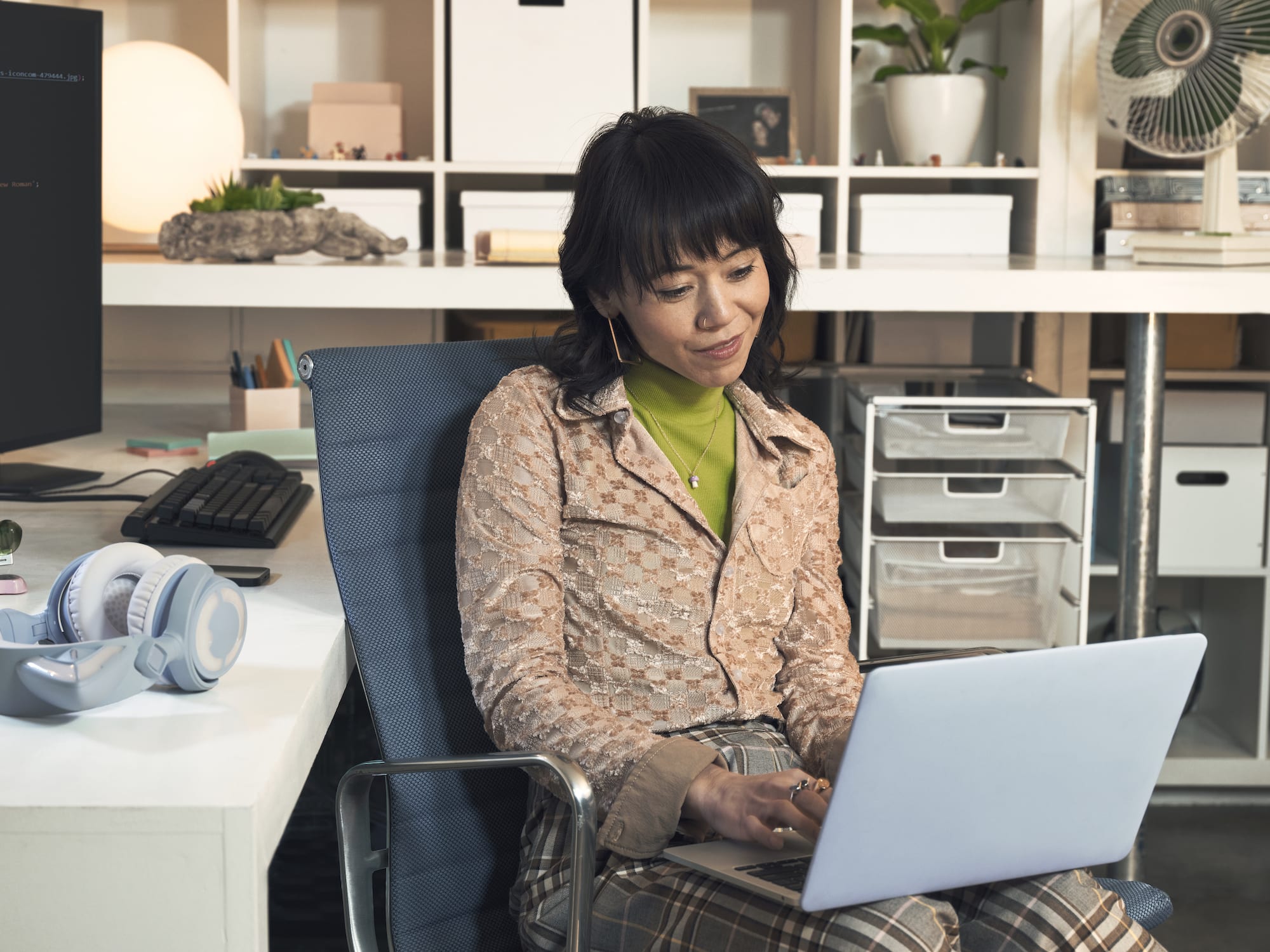 Woman standing at table talking into her computer