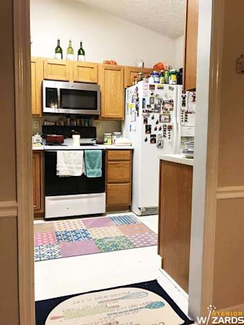 Parallel Kitchen With White Counter Top And Base And Wall Wooden