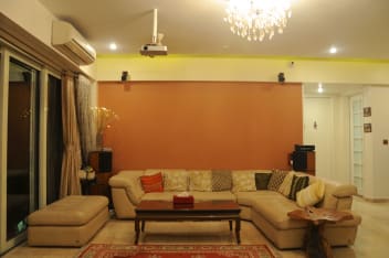 Creamy L Shaped Sofa Set With False Ceiling And Orange Wall