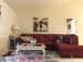 Maroon leather tuxedo couch with glass top center table and floral pattern carpet by Interior Wizards Living-room Vintage | Interior Design Photos & Ideas