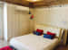 Guestroom with a white low-rise queen sized bed and upholstered headboard,designer wallpaper and hardwood fake ceiling by Chaitanya Challa Bedroom Minimalistic | Interior Design Photos & Ideas