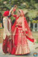 The Crimson Red Lehenga of the Bride Complimenting the Cream and Red Sherwani of the Groom by Priyanka Kamboj Wedding-photography Groom-wear-and-accessories Wedding-dresses | Weddings Photos & Ideas