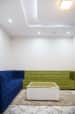 Spacious Sitting Area With Blue and Olive Green Sofas and White Centre Table by Trupti Ladda Living-room Minimalistic | Interior Design Photos & Ideas