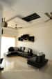 Spacious Living Room with L Shaped Black Sofa and Wooden Shelves by Manasa Bharadwaj Living-room Modern | Interior Design Photos & Ideas
