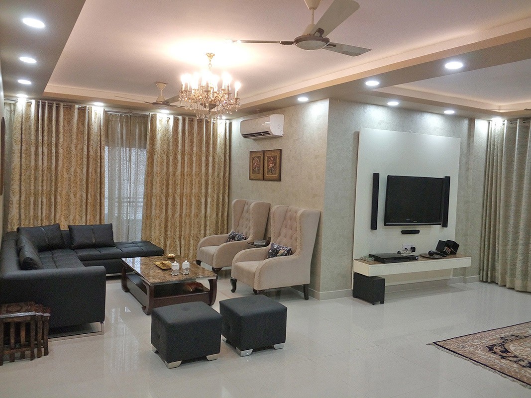 Spacious Living Room with Black L Shape Sofa Set and Beige Morgan Chairs by Ar. Barkha Jain Living-room Modern | Interior Design Photos & Ideas