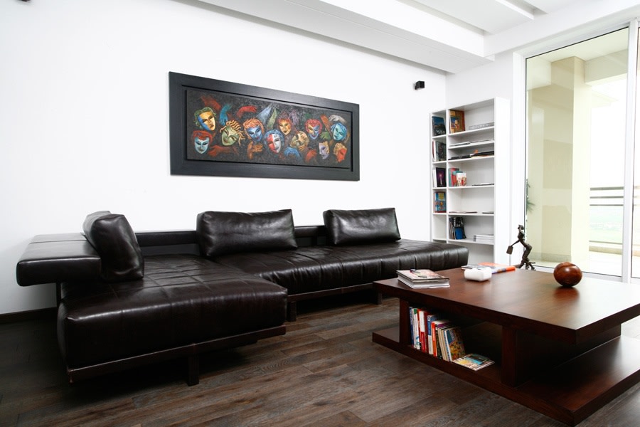 Black Sectional Sofa And Brown Wooden Table by Yogesh Goel Living-room | Interior Design Photos & Ideas