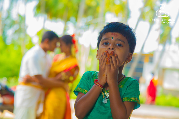 Stunning portrait of an innocent kid with the happy couple in background by Media Mads Wedding-photography | Weddings Photos & Ideas