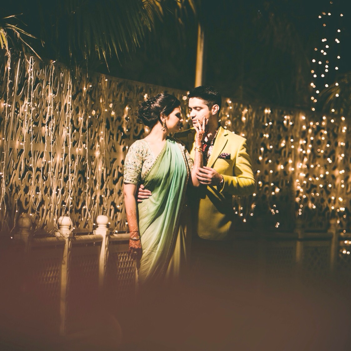 Bride and Groom Pose Against Twinkling Lights by Amanpreet Kaur Wedding-photography | Weddings Photos & Ideas