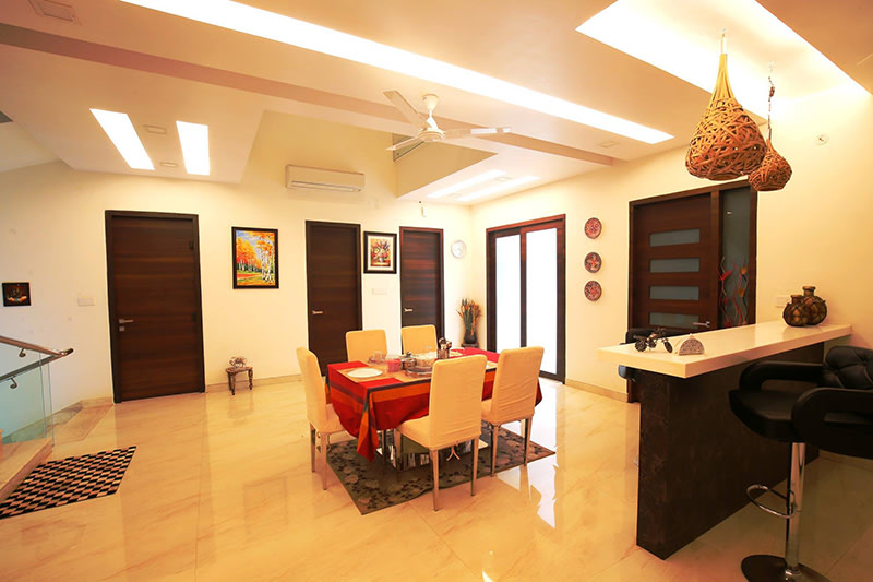 Red Dining Table With Beige Cushioned Chairs by Kraftworks Pvt. Ltd. Dining-room | Interior Design Photos & Ideas