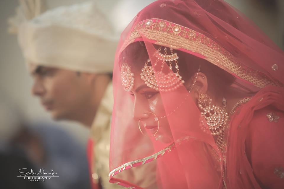 Candid Shot Of Bride Under Pink Net Veil Highlighting Her Crescent Kundan Side Mang Tikka And And Earrings by Sourab Sharma Wedding-photography | Weddings Photos & Ideas