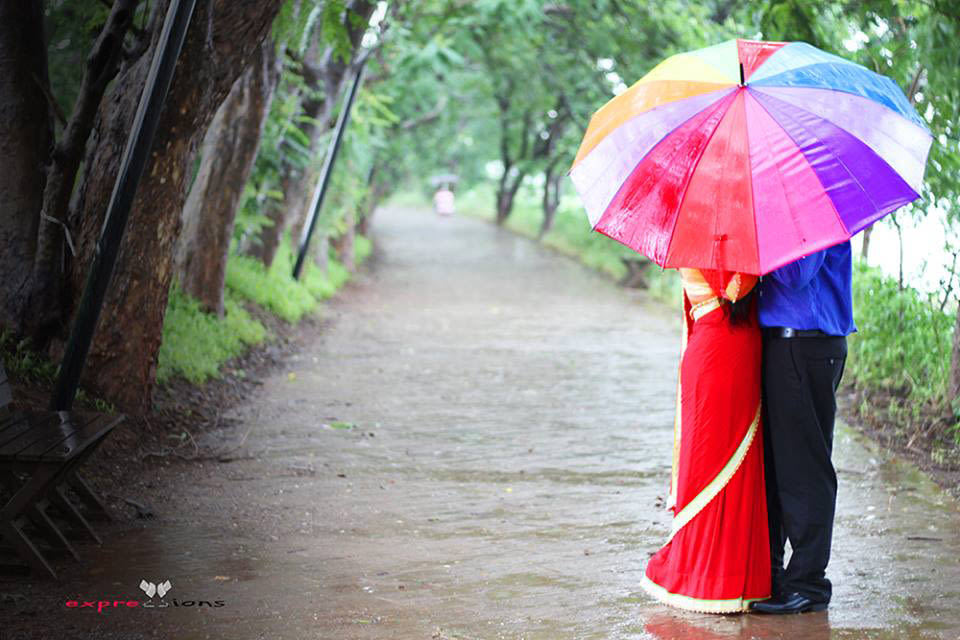 Couple sharing a colourful umbrella in the rain by Exprezzions Wedding-photography | Weddings Photos & Ideas